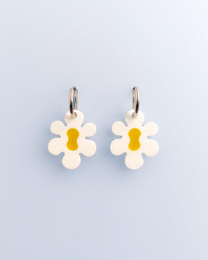 Große Retro Blumen-Ohrringe mit gelber Mitte aus Acrylglas, an silberfarbenen Edelstahl-Creolen – verspielter Modeschmuck von sweeps auf hellem Hintergrund.
