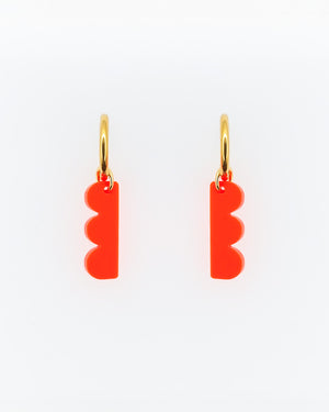 Ein paar Creolen mit orangem Bubble-Anhänger aus Acrylglas und vergoldeter Edelstahl-Creole – grafischer, leichter Schmuck von sweeps.