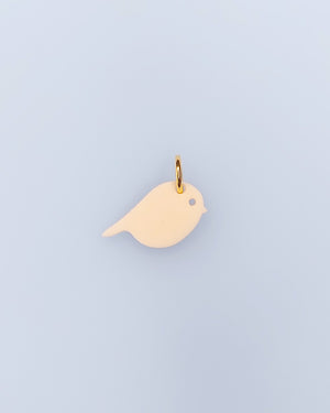 Ein elfenbeinfarbene Vogel-Schmuck-Anhänger aus Acrylglas mit Edelstahlring – sweeps mix and match 