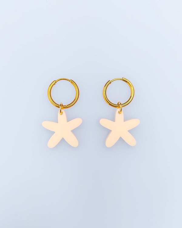 Goldene Edelstahl Creolen Hoops Ohrringe mit beigem Acrylglas Anhänger in Seesternform.