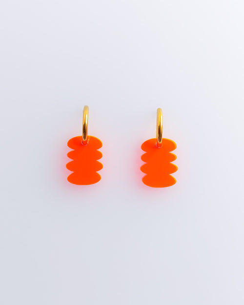 Zwei Ohrringe mit Neon orangen grafischen Anhängern aus Edelstahl und Acrylglas.