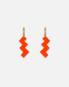 Goldene Creolen mit grafischen Zick-Zack Anhänger aus neon-orangem Acrylglas.