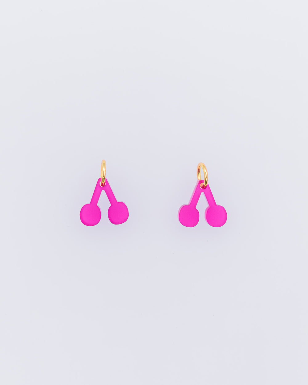 Zwei Fuchsia rote Acrylglas Kirschen Anhänger für Ohrringe oder Halsketten auf weißem Hintergrund von sweeps.