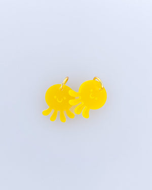 Zwei gelbe Quallen Ohrring oder Schmuckanhänger mit graviertem Gesicht aus satiniertem Acrylglas und vergoldeten Edelstahl-Ringen.
